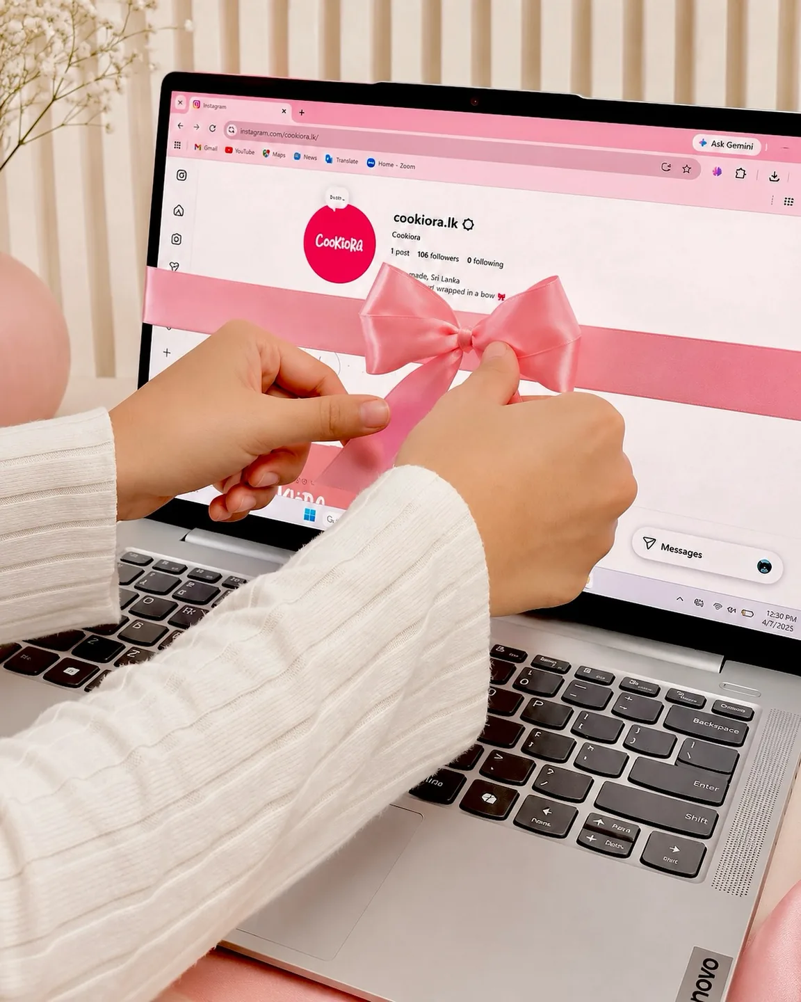 Hands tying a pink ribbon around a laptop showing the Cookiora Instagram page