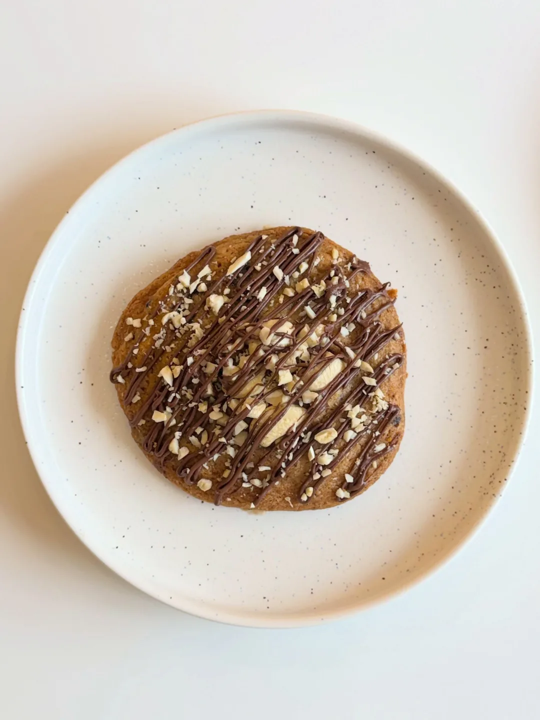 Almond Chocolate cookie on a white plate, from the Cookiora Instagram post